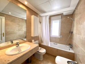 Ein modernes Badezimmer mit Waschbecken, Toilette und Badewanne.