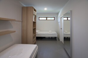 A compact bedroom with a single bed, a wooden wardrobe, and a mirror on the right wall. - River house for relaxation and remote work station (nakornpathom)
