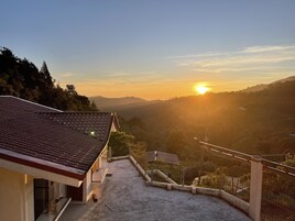 Um edifício com telhado cerâmico com vista para um vale.