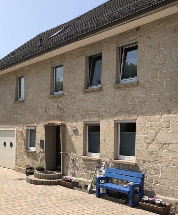 A stone building with multiple windows and a garage.