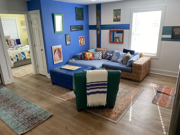 A living room with a blue accent wall, a sofa, a green armchair, and a coffee table.