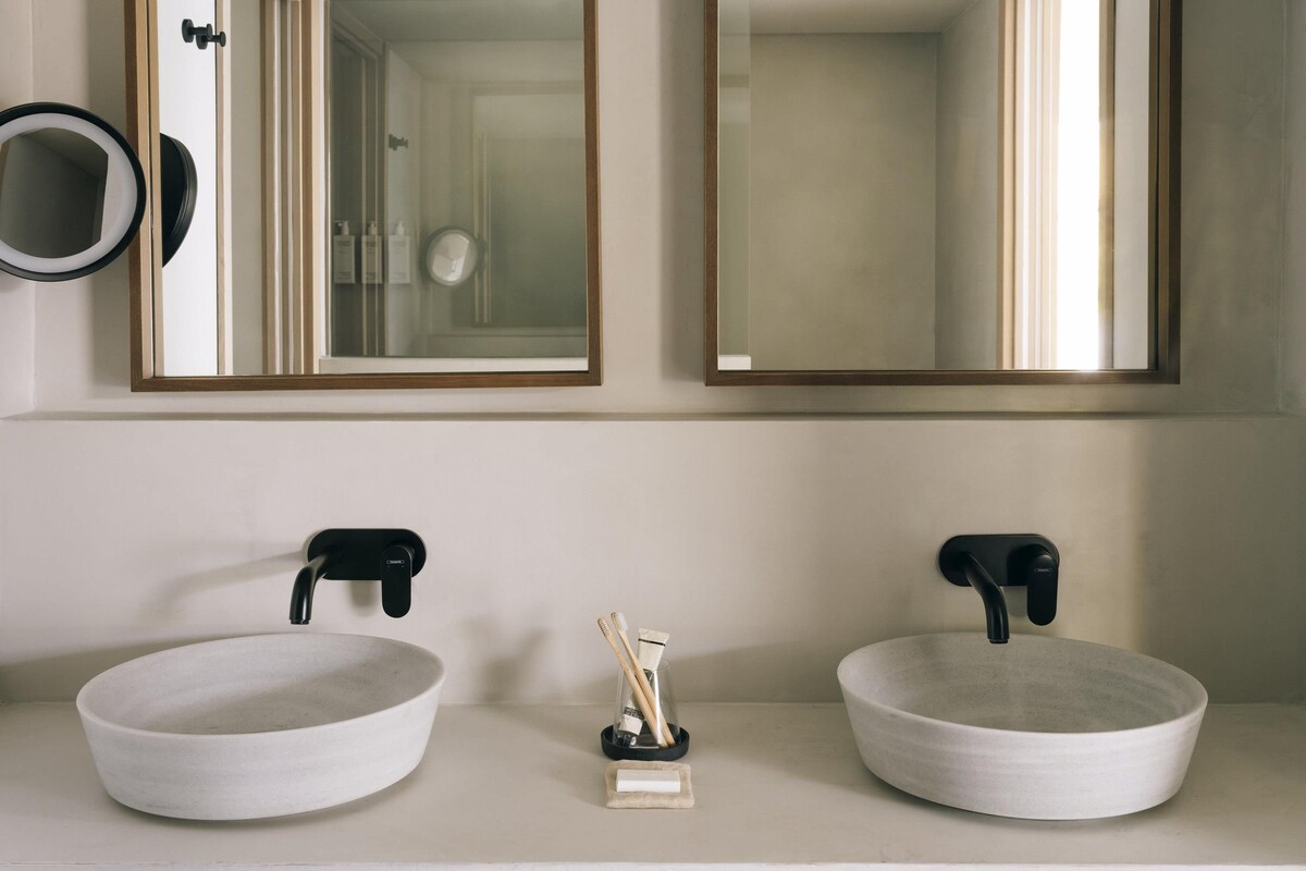 A bathroom with two sinks, each with a black faucet, and a mirror above.