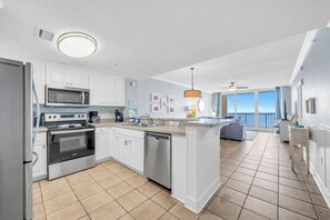 A modern kitchen with white cabinetry, stainless steel appliances, and a central island.