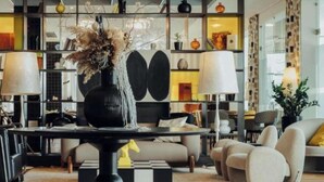 A modern living room with a central table, sofas, and a decorative wall with shelves. - Ibis Styles Warszawa Airport (Warsaw)