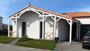 Il s’agit d’un bâtiment d’un seul étage, doté d’un toit en tuiles et de murs extérieurs blancs. Une allée couverte mène à un garage.