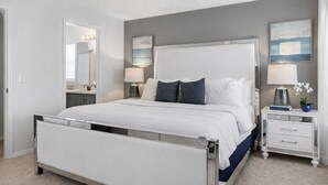 A modern bedroom with a large bed, bedside tables, a mirror, and artwork on the walls. - Star Wars Arcade Theater & Private Pool Villa | 3 Kings | Near Disney (Clermont)