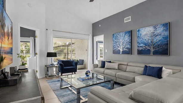 A modern living room with a sofa, armchairs, a coffee table, and artwork on the walls. - Star Wars Arcade Theater & Private Pool Villa | 3 Kings | Near Disney (Clermont)