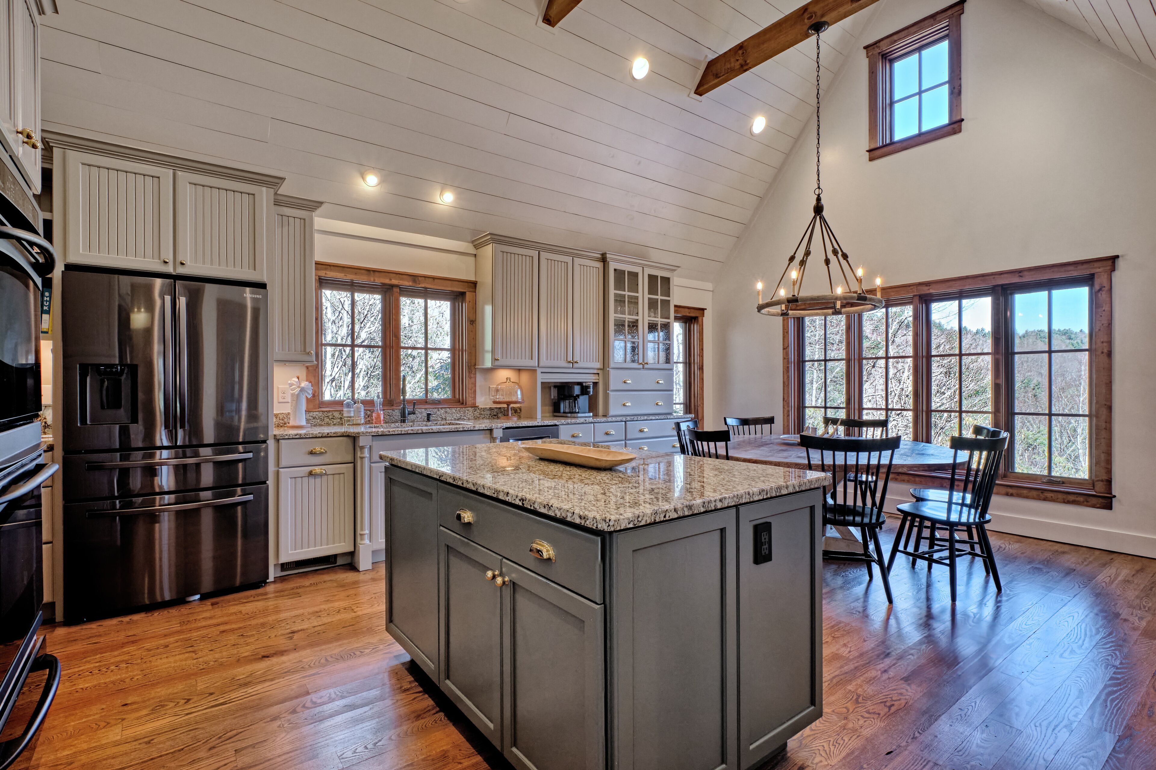 A spacious kitchen with a large island, stainless steel appliances, and ample natural light from large windows.