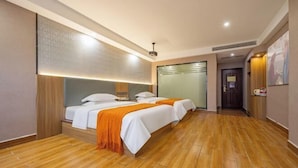 A hotel room with two beds, wooden flooring, a large mirror, and a door leading to another room. - Xiangli Hotel (Shawan Park Subway Station, Changsha High Speed Railway South Station) (Changsha)