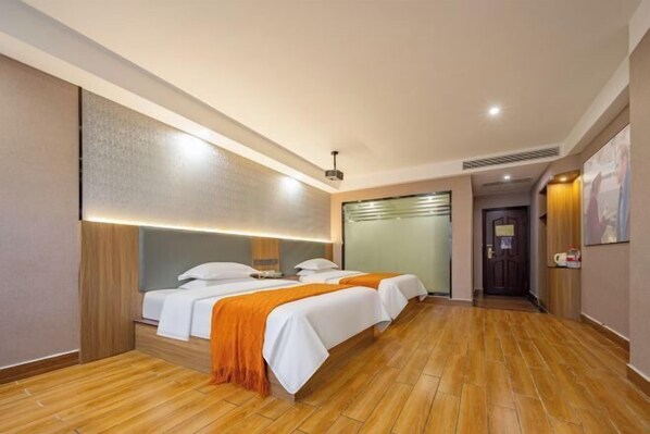 A hotel room with two beds, wooden flooring, a large mirror, and a door leading to another room. - Xiangli Hotel (Shawan Park Subway Station, Changsha High Speed Railway South Station) (Changsha)
