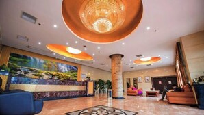 A hotel lobby with a reception desk, a large chandelier, and a patterned floor design. - Xiangli Hotel (Shawan Park Subway Station, Changsha High Speed Railway South Station) (Changsha)