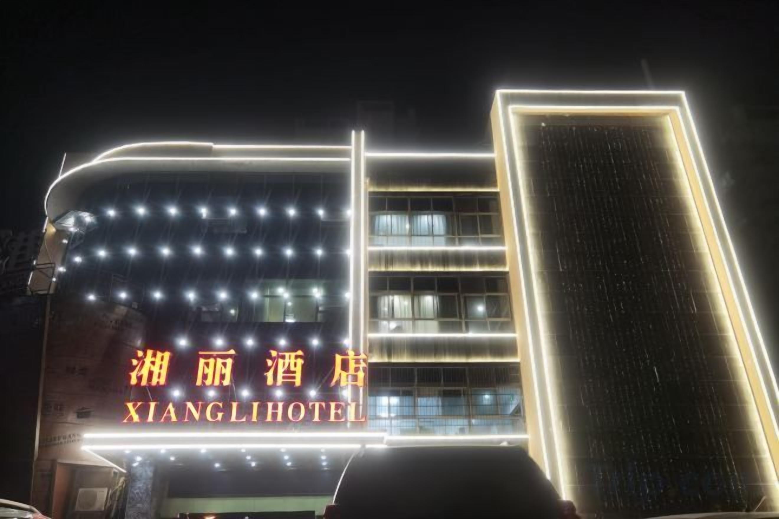 A hotel with a prominent illuminated sign, a modern architectural design, and a visible entrance.