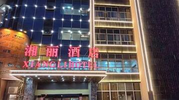 A hotel with a prominent sign, multiple floors, and a modern architectural design.