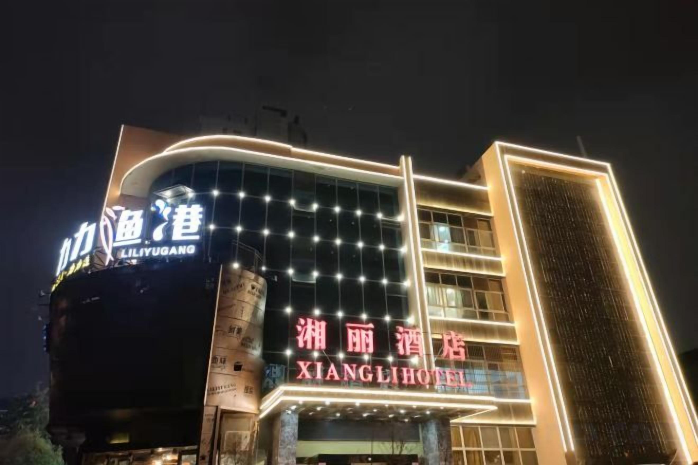 A hotel with illuminated signage, a modern facade, and a prominent entrance.