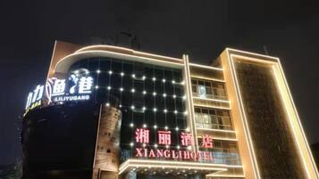 A hotel with illuminated signage, a modern facade, and a prominent entrance.