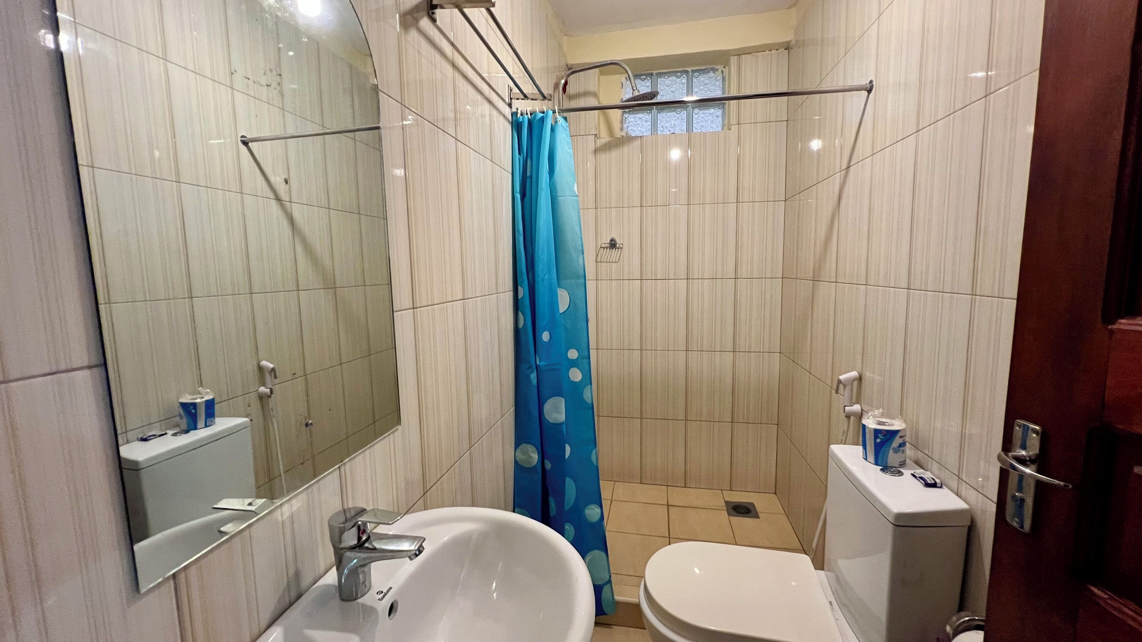 A bathroom with a sink, toilet, and shower area.