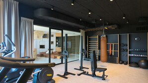 A modern gym with cardio equipment, weightlifting stations, and a punching bag. - Gdańska 21R /5 (Gdansk)
