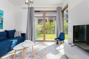 En moderne stue med en blå sofa, et hvidt sofabord og en blå lænestol.
