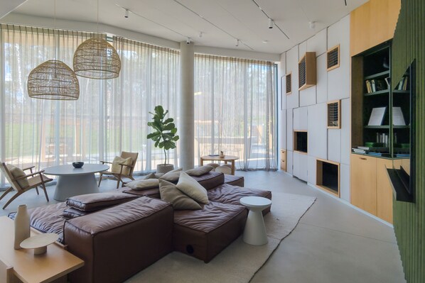 Een moderne woonkamer met een hoekbank, een ronde salontafel en een eethoek met stoelen.