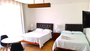 A hotel room with two beds, a dining table, and chairs. - Casablanca (Santiago de Surco)
