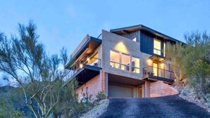A modern two-story house with a flat roof, large windows, and a balcony. - “Windmill House” -Mountain/City views, super close to great hiking trails (Phoenix)