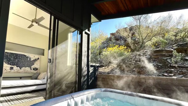 A hot tub with a view of a rocky landscape and a map on the wall. - “Windmill House” -Mountain/City views, super close to great hiking trails (Phoenix)