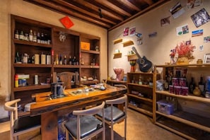 A room with a wooden table, chairs, shelves with various items, and a wall with pictures and decorations. - Lijiang Longfeng Villa (Shuhe Ancient Town Branch) (Lijiang)