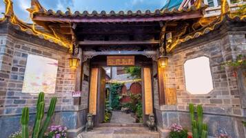 A traditional Chinese gate with ornate decorations and a stone pathway leading through it.