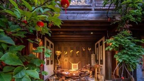 A traditional wooden interior with a central seating area, surrounded by plants and decorative elements. - Lijiang Longfeng Villa (Shuhe Ancient Town Branch) (Lijiang)