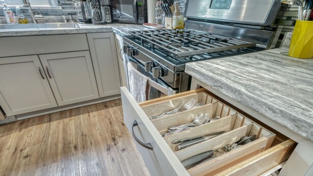 A kitchen with a stainless steel stove, a drawer with utensils, and a marble countertop. - Walkable to RIT/Comfortable Stay near university (Rochester)