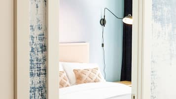 A bedroom with a bed, a bedside lamp, and a wall-mounted light fixture.
