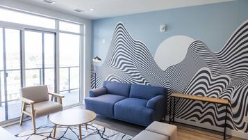 A modern room with a blue sofa, a round table, and a patterned rug.