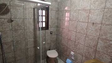 Chuveiro, chinelos, toalhas de banho, papel higiênico