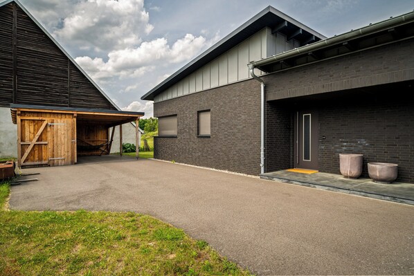 A modern building with a garage, a brick facade, and a metal roof.