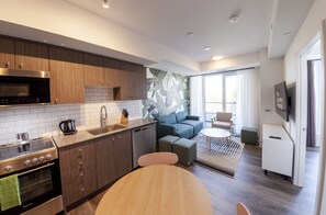 Apartamento Deluxe | Zona de estar | Smart TV de 55 pulgadas con canales digitales, una televisión