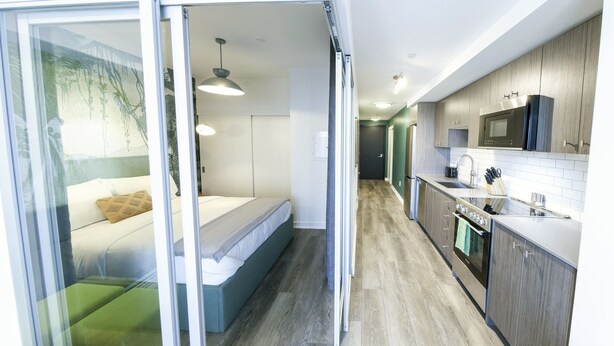 A modern kitchen with a microwave, oven, and sink. - The Laundry Rooms Station Park Kitchener (Kitchener)