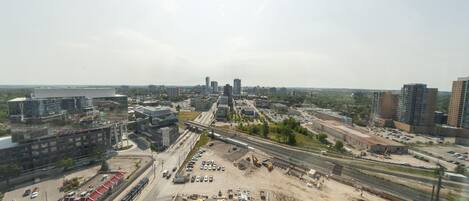 An aerial view of a cityscape with a highway, parking lots, and construction areas.