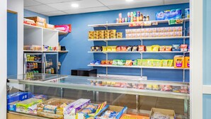 A candy and snack display in a store with various products on shelves and in a glass case. - Travelodge by Wyndham Livonia/Canton/Novi Detroit Area (Livonia)