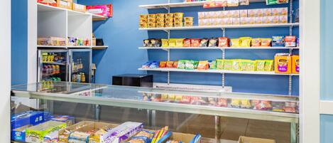 A candy and snack display in a store with various products on shelves and in a glass case.
