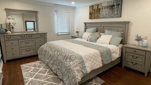 A bedroom with a bed, dresser, nightstands, and a painting on the wall. - Buzzards bay hide away (Bourne)