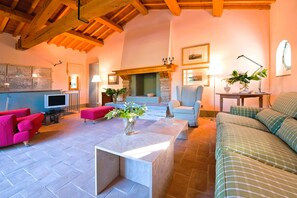A spacious living room with a fireplace, a television, and comfortable seating.