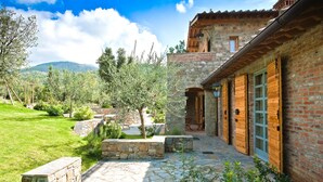 A stone pathway leading to a wooden building with a stone wall and a view of mountains. - Villa Leccino in most Exclusive Borgo in Tuscany (Pian di Sco)