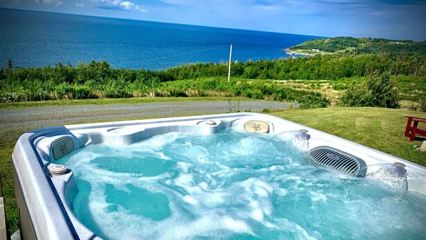 Un bain à remous avec vue sur l’océan et la végétation environnante.