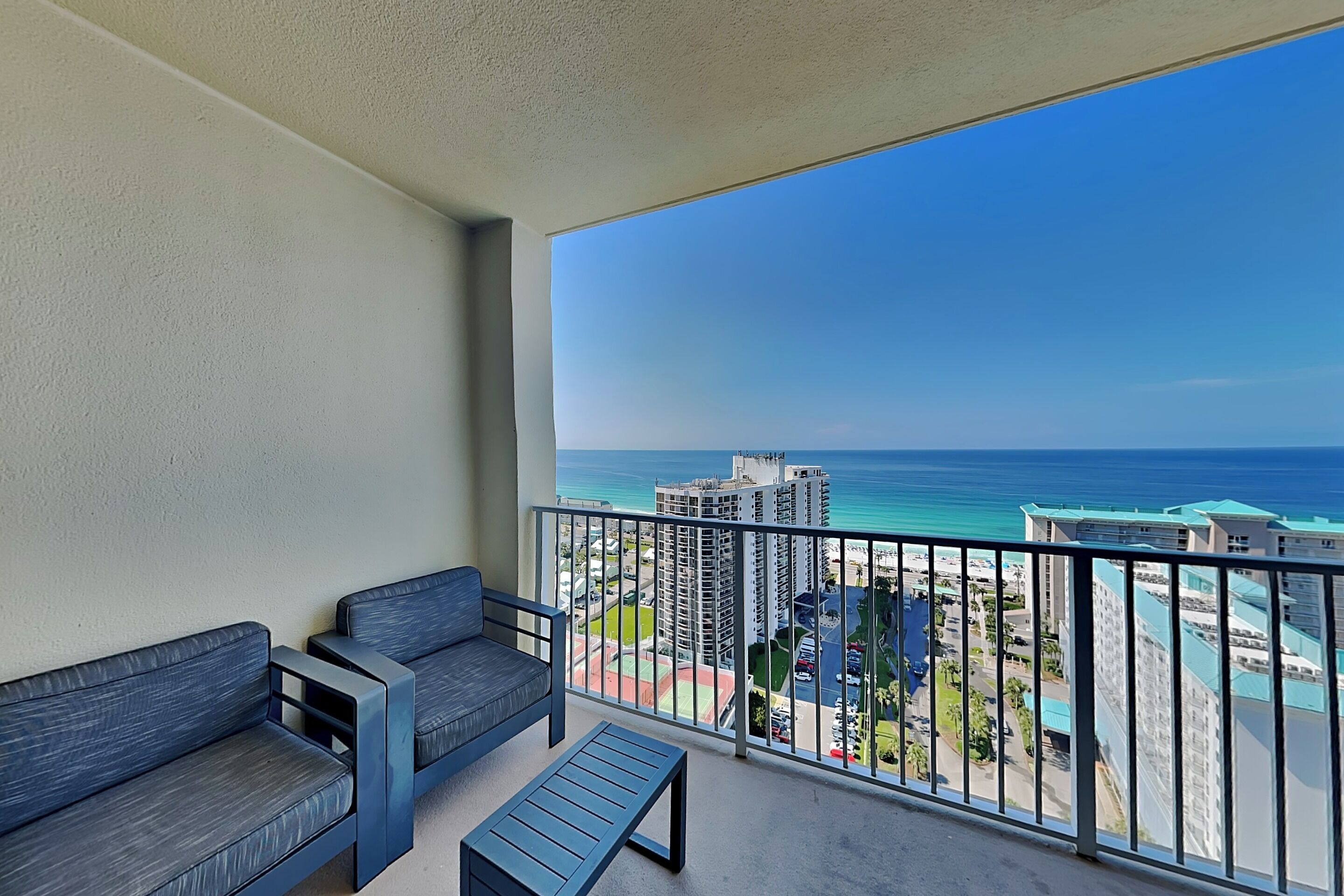 A balcony with a view of the ocean and buildings.