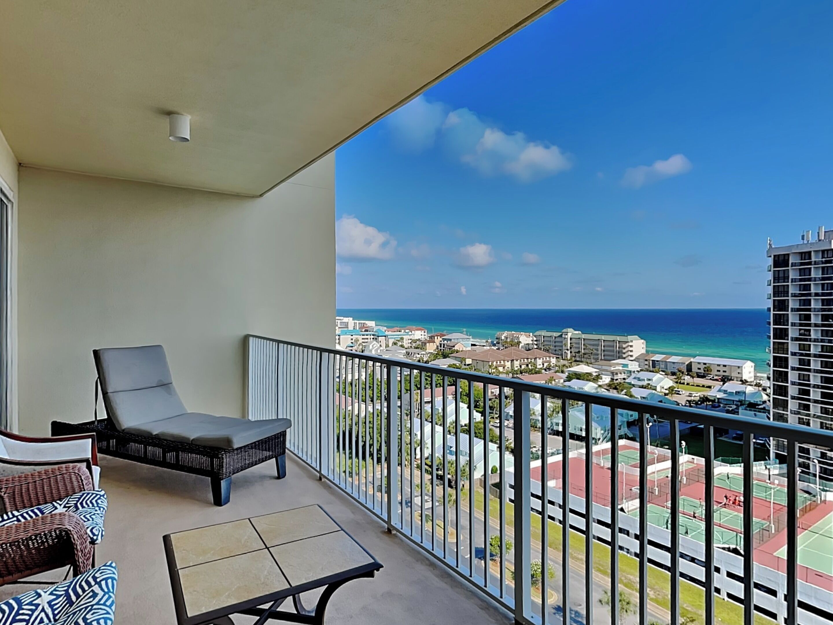A balcony with a view of the ocean and buildings.