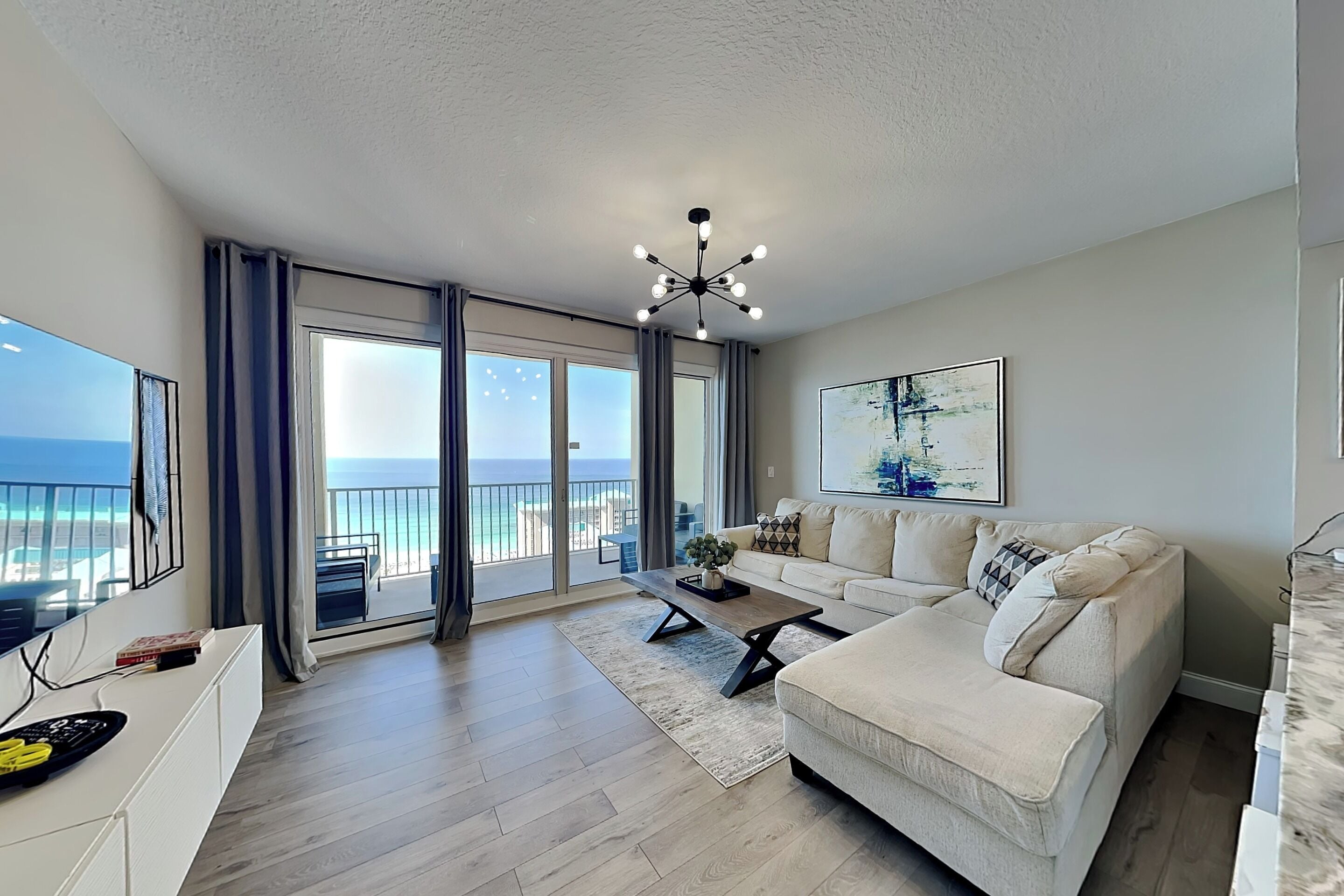 A spacious living room with a large window, a ceiling fan, and a sofa.