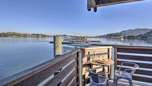 A wooden deck with a table and chairs overlooking a calm lake with boats and distant hills. - Floating condo 'C' on Sausalito's Richardson Bay (Mill Valley)
