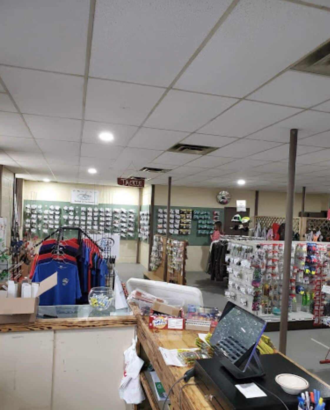 A retail store with clothing racks, shelves with various items, and a checkout counter.
