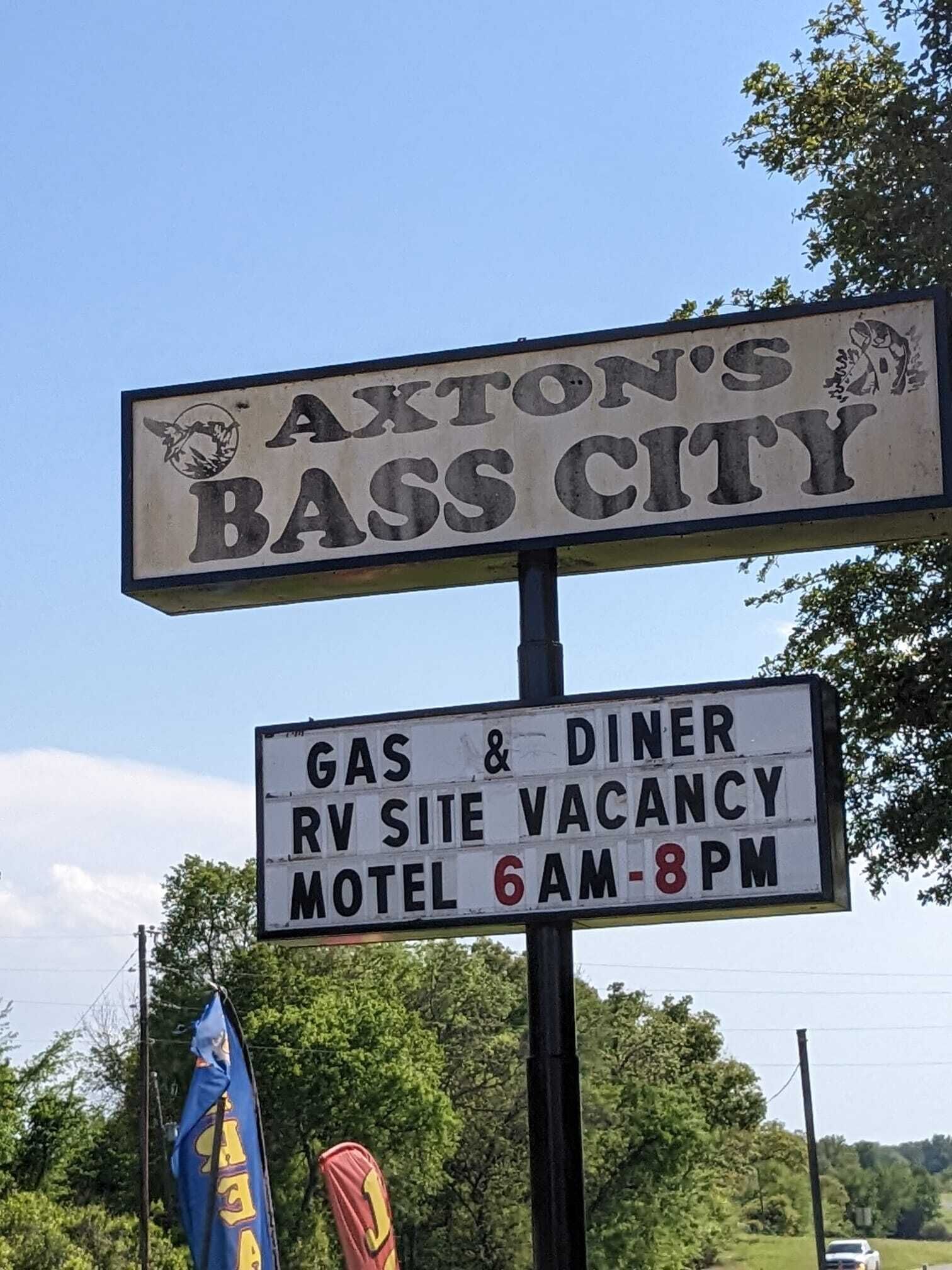 Schild für Axton's Bass City, das einen Tankstelle und Diner, freie Stellplätze für Wohnmobile und ein Motel von 6 bis 20 Uhr anzeigt.