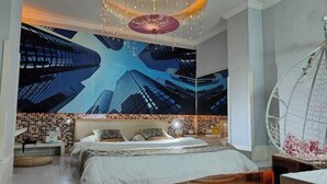 A modern bedroom with a large bed, a hanging chair, and a cityscape mural on the wall. - Jiahua Business Hotel (Guangzhou North Railway Station Huacheng Road Subway Station) (Guangzhou)